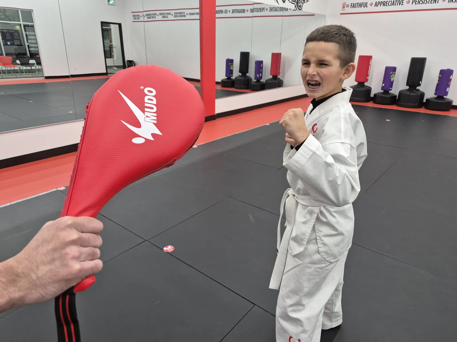 Young student kicking a pad