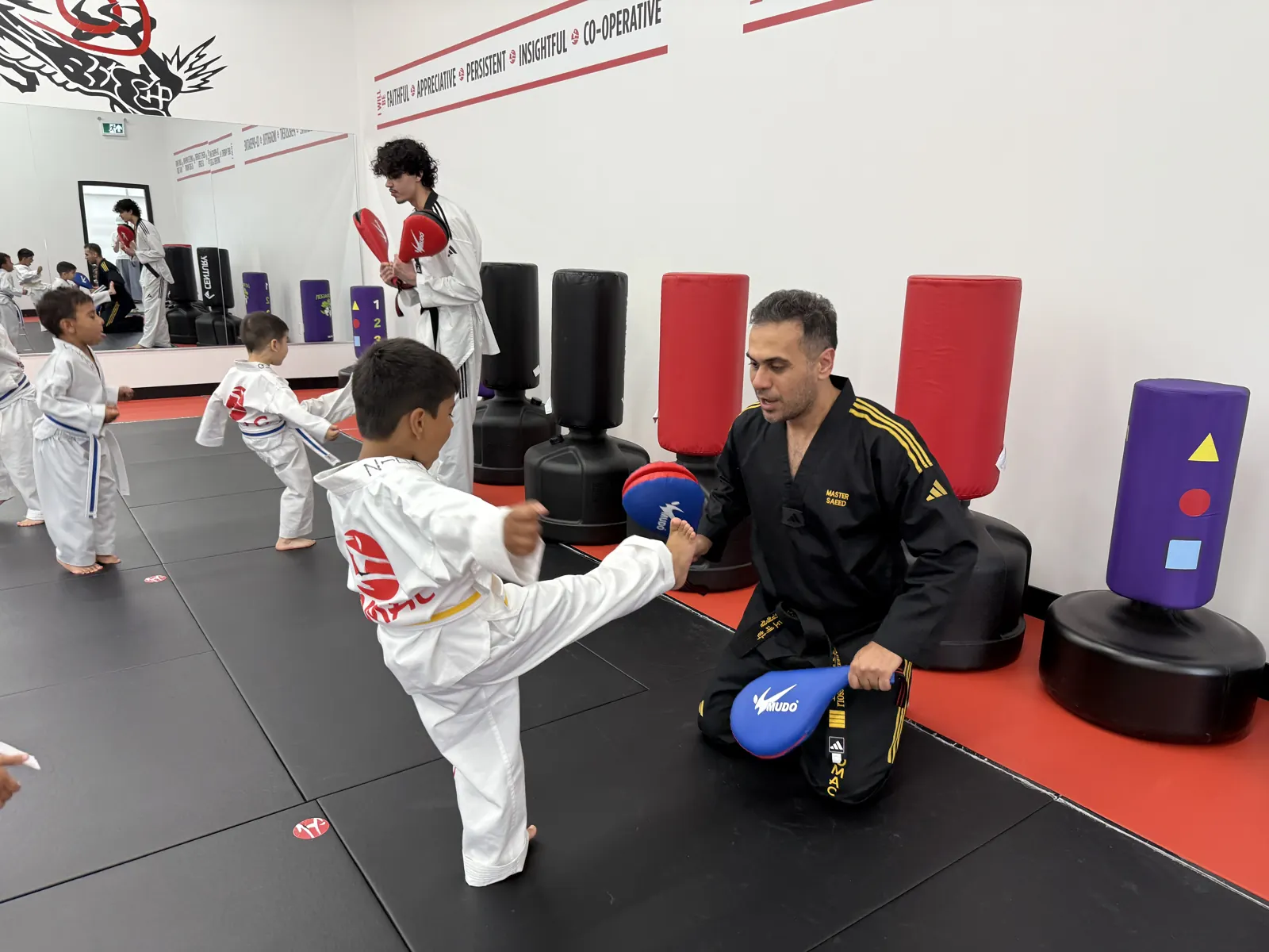 Instructor holding a pad for a young student